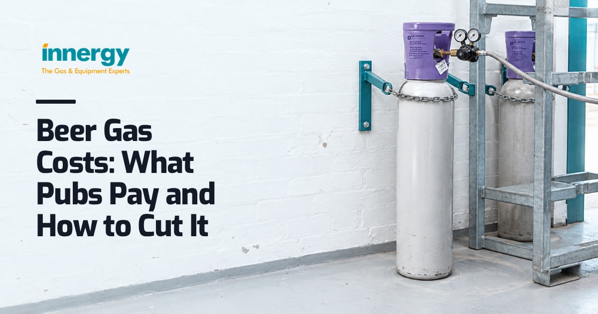 Two gas cylinders chained to a whitewashed pub cellar wall, one connected and one dusty behind steel keg stillage, with the words "Beer Gas Costs: What Pubs Pay and How to Cut It" set on it